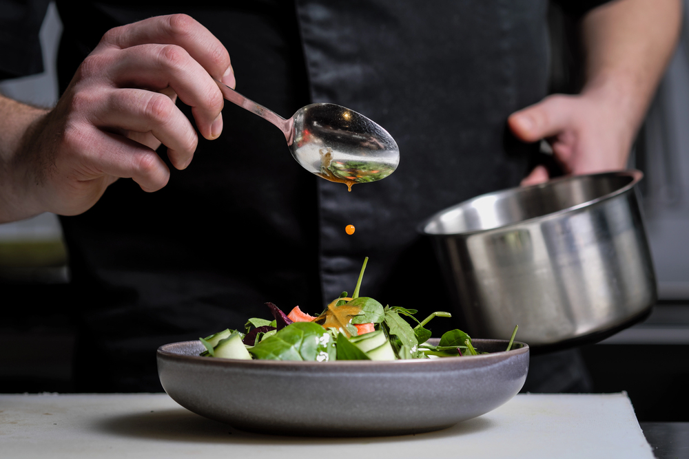 Chef dishing plate of greens