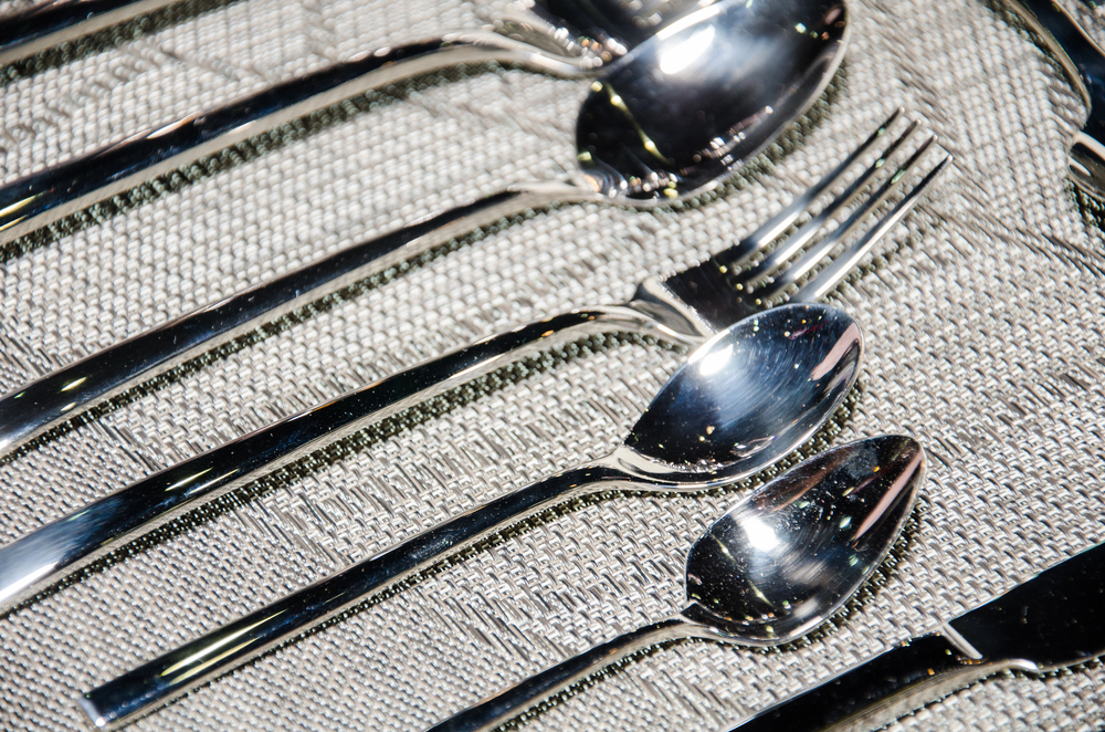 Shiny flatware on a patterned backdrop