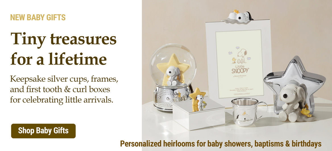 Silver baby gifts including a baby cup, baby spoon and fork, and a silver baby rattle.