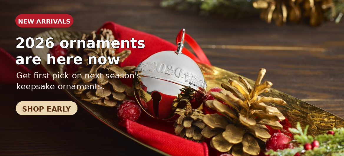 Wallace Silver Plate Sleigh Bell with red decorations behind it